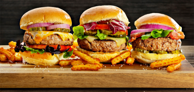 maryland food photographer - three burgers with veggies and buns on wood cutting board