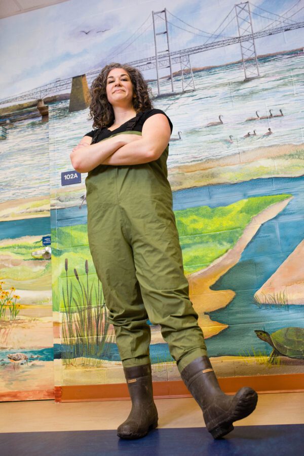 frederick portrait photographer captures natural headshot of woman with dark hair in green waders and boots with with a mural in the background