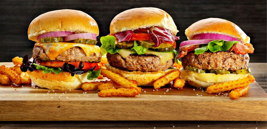 Three incredible hamburgers with cheese and all the fixings, plus fries