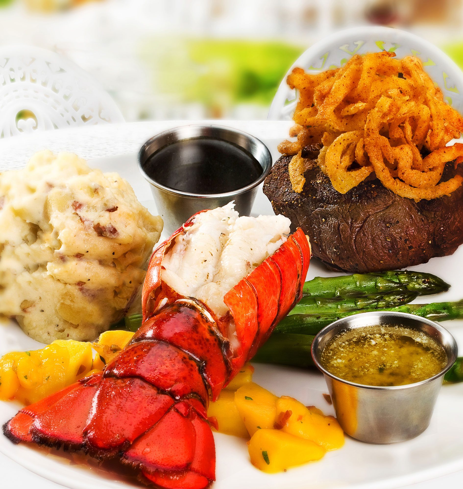 Lobster tail, filet mignon, asparagus and potatoes in outdoor setting
